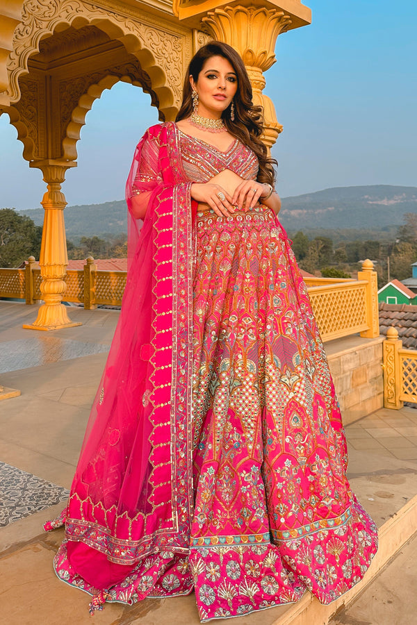Kashni Bridal Lehenga in bold pink with mirror work and floral motifs, designed for Dubai weddings.