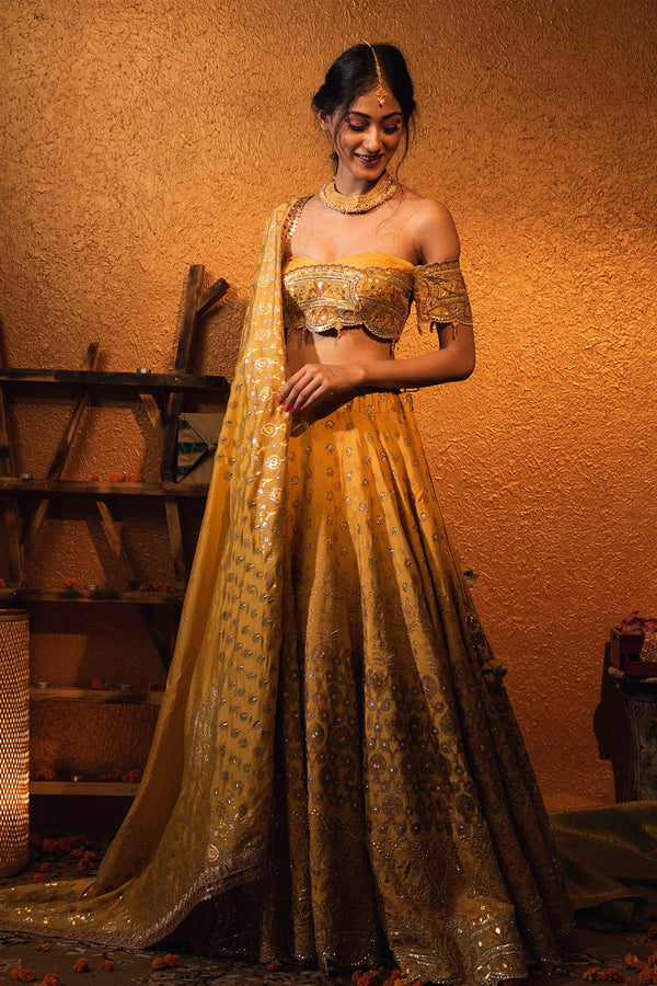 Saima Lehenga Set in yellow with an off-shoulder blouse, antique embroidery, and silk dupatta.